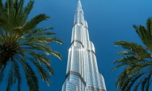 Burj Khalifa, najwyższy budynek świata, ma 163 piętra. Widok zza palm na błękitne niebo.
