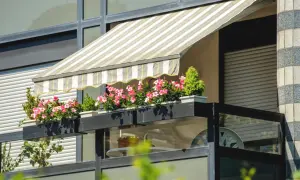 Pnąca się po balustradzie z kwiatami, markiza to świetny sposób, jak osłonić balkon w bloku przed słońcem.