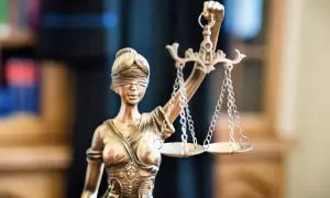 Figurka Temidy z wagą symbolizuje sprawiedliwość, kluczową przy zawieraniu umowy rezerwacji mieszkania.