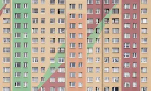 Kolorowy blok mieszkalny z wieloma oknami. Szukasz sposobu, jak przyspieszyć dostanie mieszkania komunalnego?