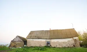 Dwa stare budynki gospodarcze, jeden z kamienia, drugi z tynkiem, wymagają remontu. Zastanawiasz się, jak zalegalizować budynek gospodarczy?