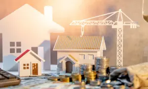 Model domków, monety, kalkulator i klepsydra symbolizują zakup mieszkania od dewelopera krok po kroku.
