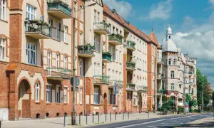 Kamienice z balkonami i zielenią. Czy teren wspólnoty mieszkaniowej jest terenem prywatnym? Pytanie to nasuwa się, patrząc na zadbane fasady i chodnik.