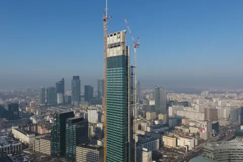 Varso Tower w budowie, z dźwigami na szczycie, góruje nad panoramą Warszawy. Trudno ocenić, ile pięter ma Varso Tower, ale jest to już najwyższy budynek w Polsce.