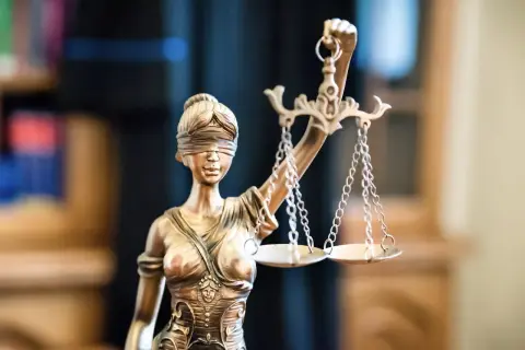 Figurka Temidy z wagą symbolizuje sprawiedliwość, kluczową przy zawieraniu umowy rezerwacji mieszkania.