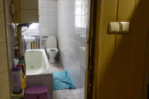 W łazience z wanną, toaletą i umywalką, widać, że lokal socjalny musi mieć łazienkę.