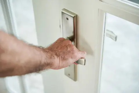 Dłoń otwiera drzwi. Czy osoba zameldowana ma prawo do mieszkania?