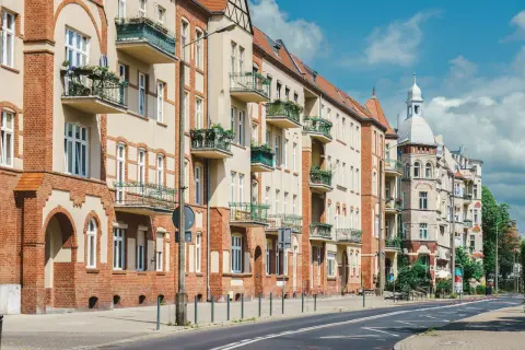 Kamienice z balkonami i zielenią. Czy teren wspólnoty mieszkaniowej jest terenem prywatnym? Pytanie to nasuwa się, patrząc na zadbane fasady i chodnik.