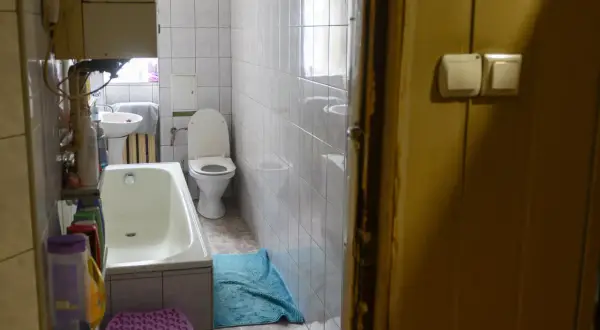 W łazience z wanną, toaletą i umywalką, widać, że lokal socjalny musi mieć łazienkę.