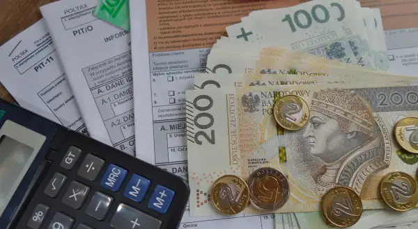 Kalkulator, polskie banknoty i monety na dokumentach podatkowych. Dowiedz się, jak odliczyć kredyt hipoteczny od podatku.