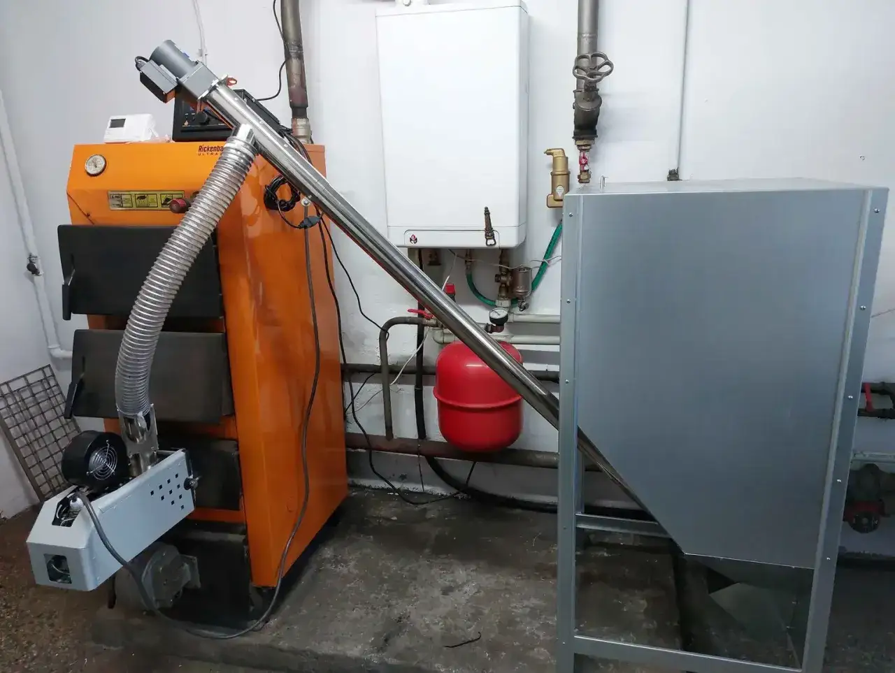 Instalacja do przeróbki pieca na ekogroszek na pellet: podajnik ślimakowy, palnik i zasobnik.