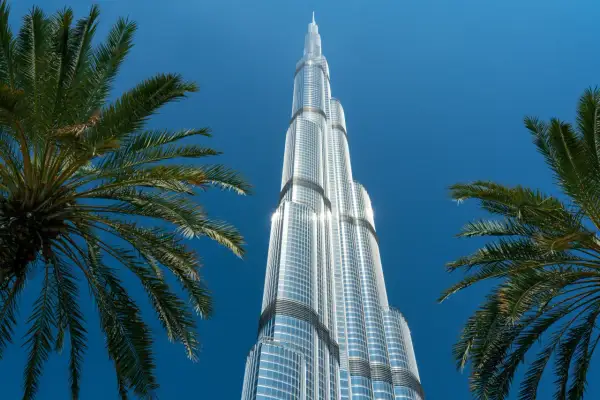 Burj Khalifa, najwyższy budynek świata, ma 163 piętra. Widok zza palm na błękitne niebo.