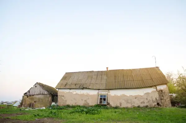 Dwa stare budynki gospodarcze, jeden z kamienia, drugi z tynkiem, wymagają remontu. Zastanawiasz się, jak zalegalizować budynek gospodarczy?
